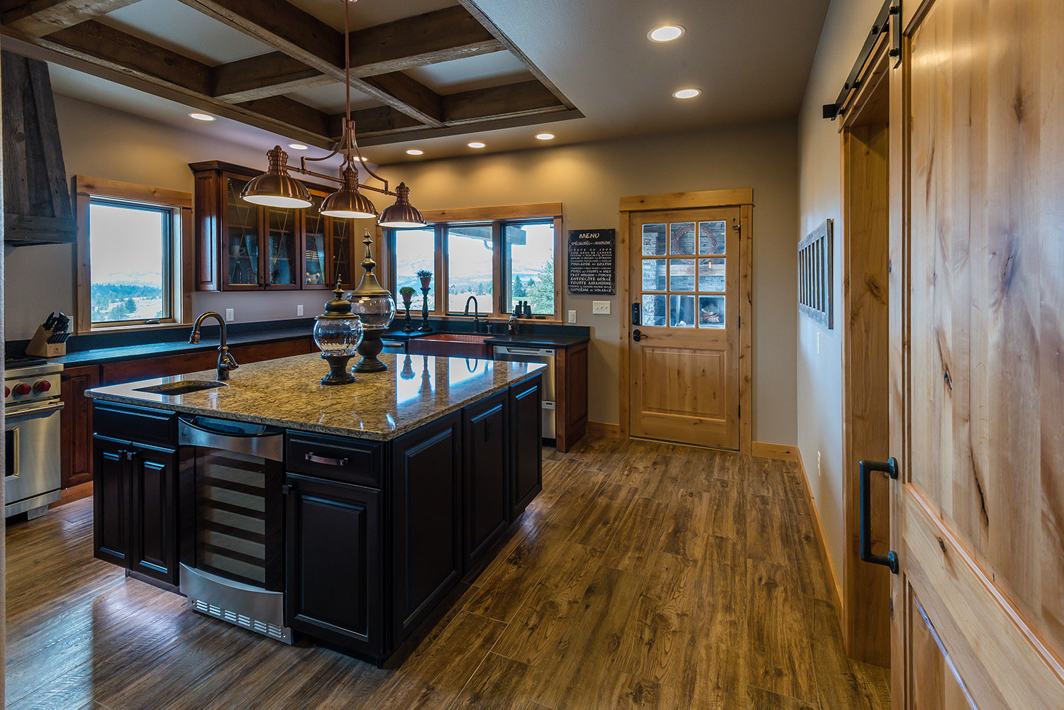 Rustic kitchen with granite countertops and copper farmhouse sink and exposed wood beams in ceiling